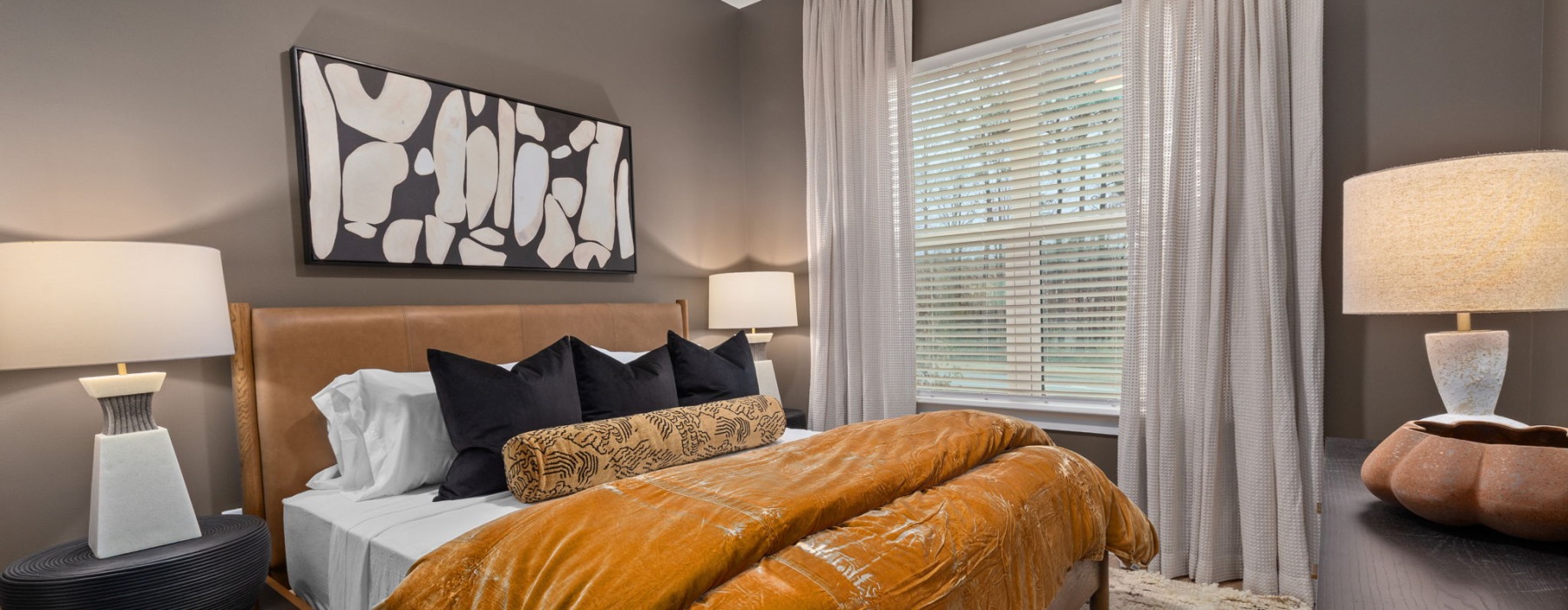Furnished bedroom with large bed and nightstands in a 1 bedroom apartment in Cary, NC at Emorie.
