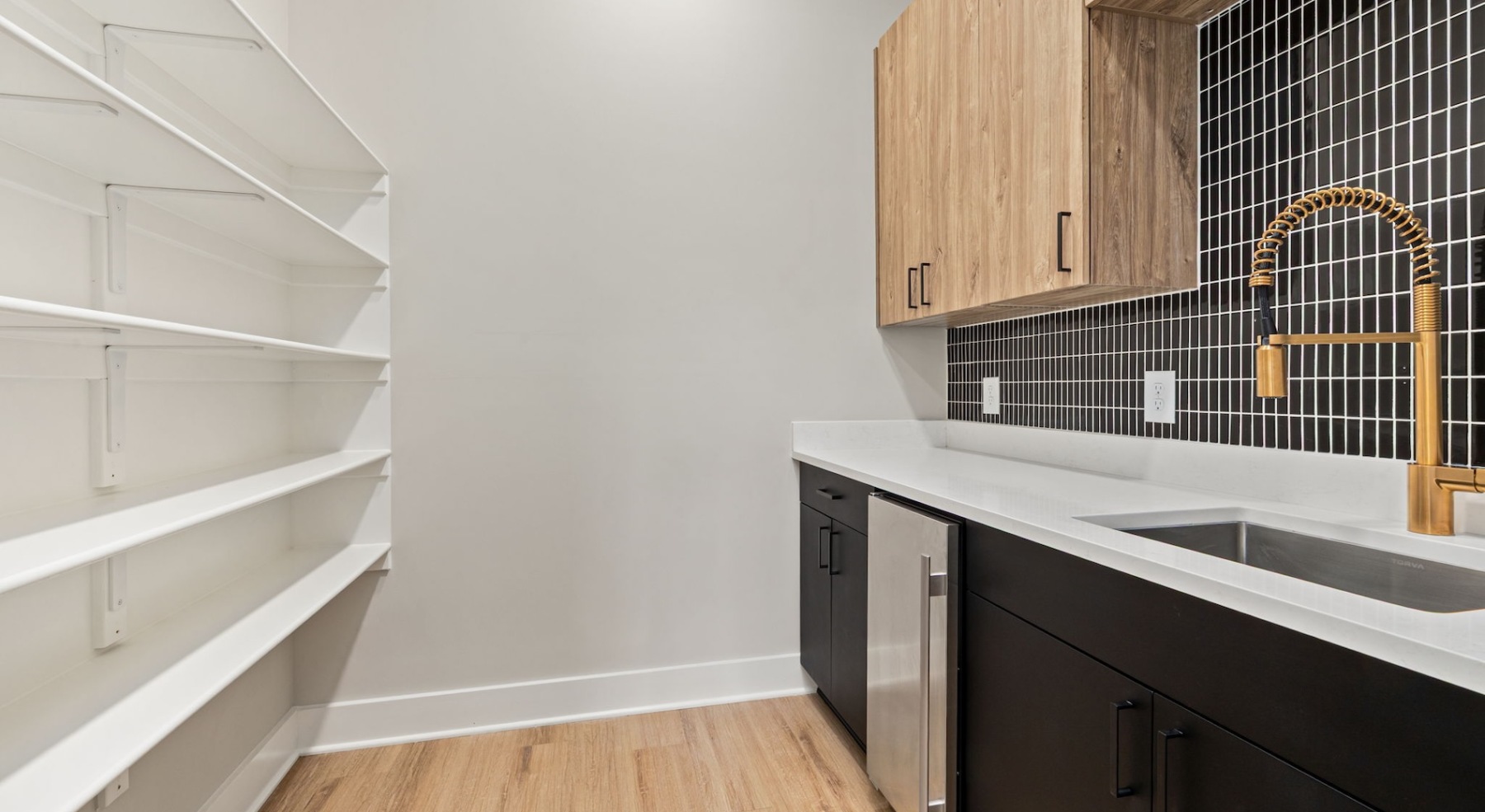 spacious room with shelves, a sink, and a fridge