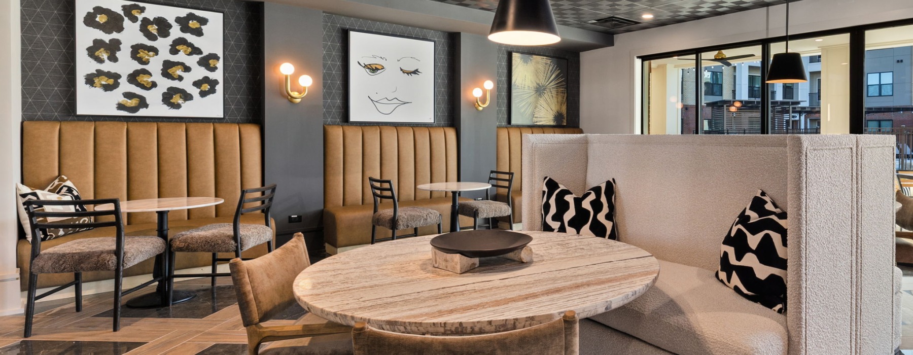 Community lounge with booth seating and tables at Emorie apartments near Research Triangle Park in Durham, NC.